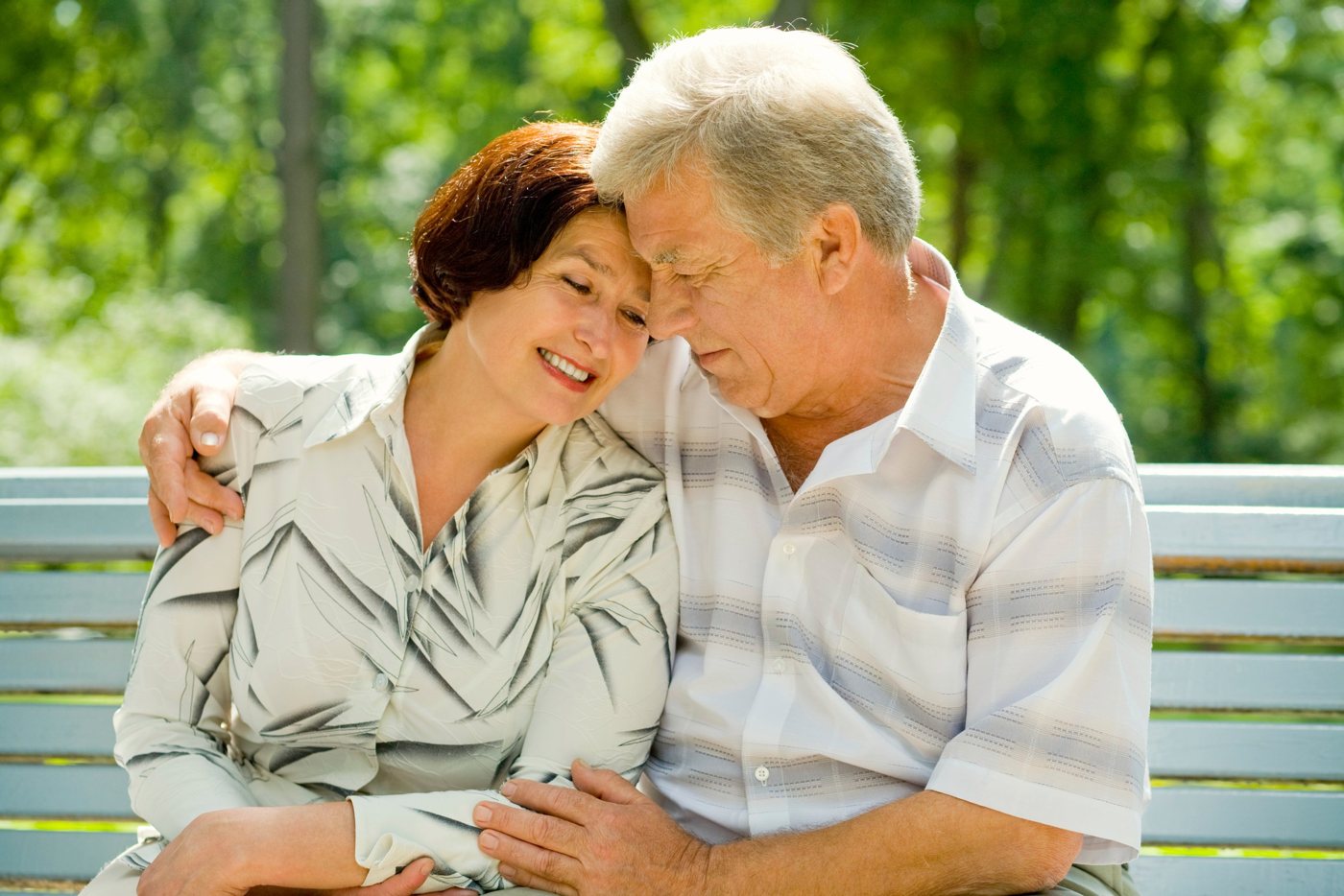 Happy older couple sitting together in a park