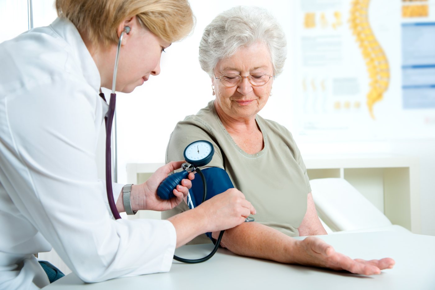 Doctor checking an older woman's blood pressure